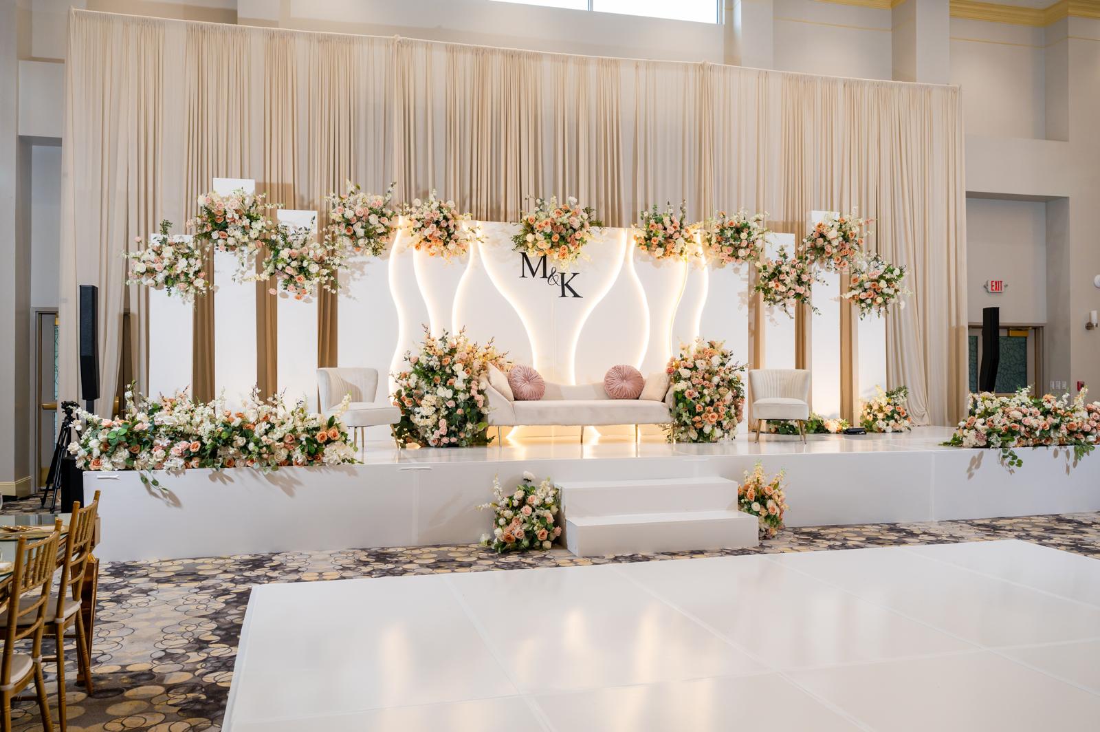 Floral stage and banquet setting inside The Pearl Event Center